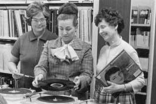 Librarians using a record player