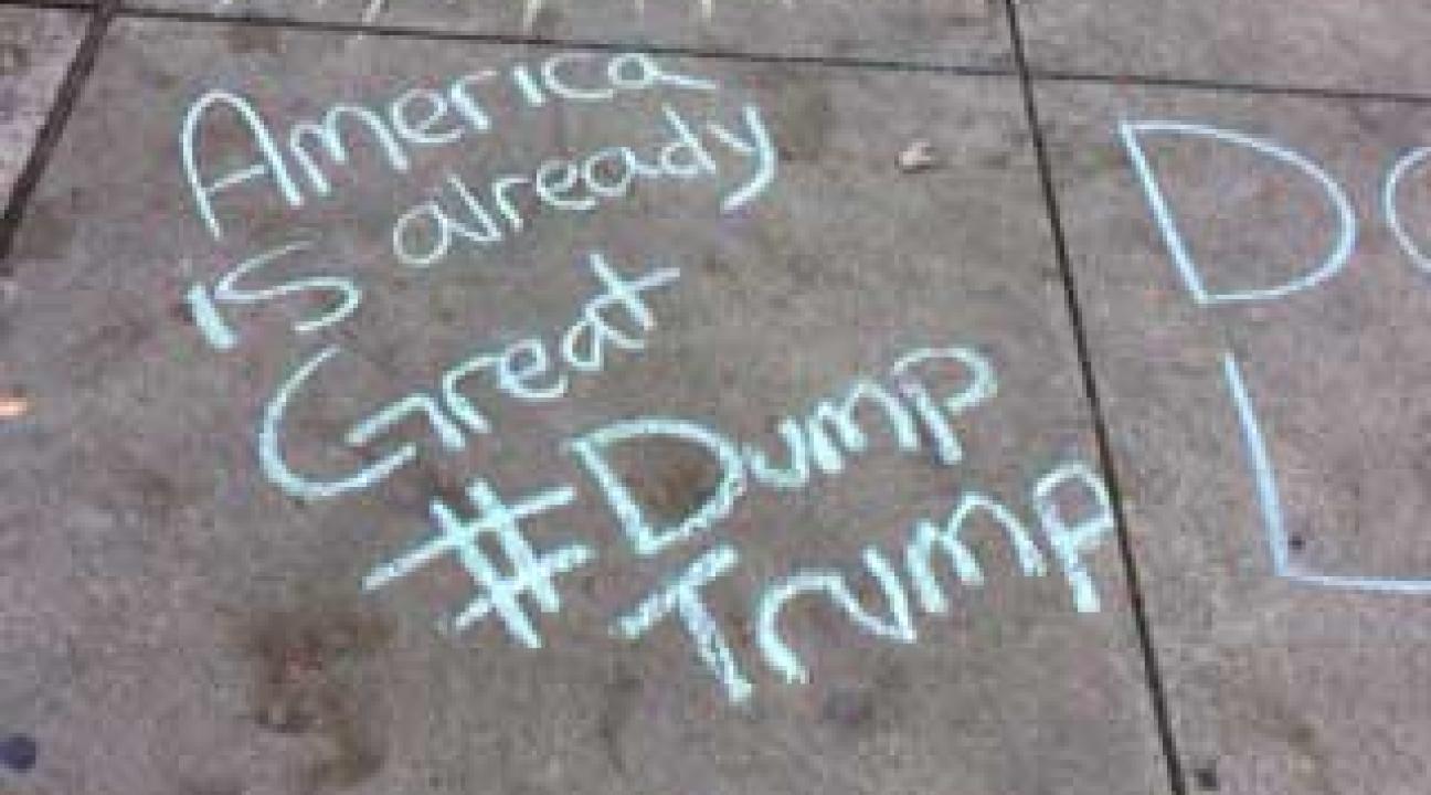 Chalk text of "America is already great #Dump Trump"
