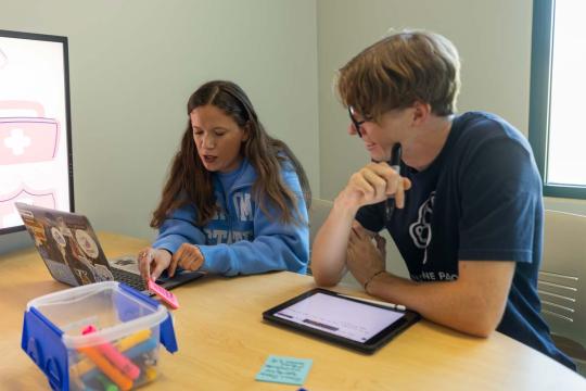 Two students studying together in a group study room