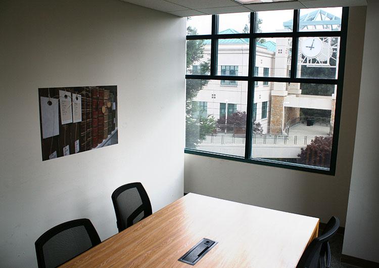 Unoccupied study room with a window, desk and 2 chairs.