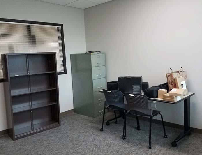 View of the VITaL lab, one desk with VR equipment, bookcase and file cabinet.