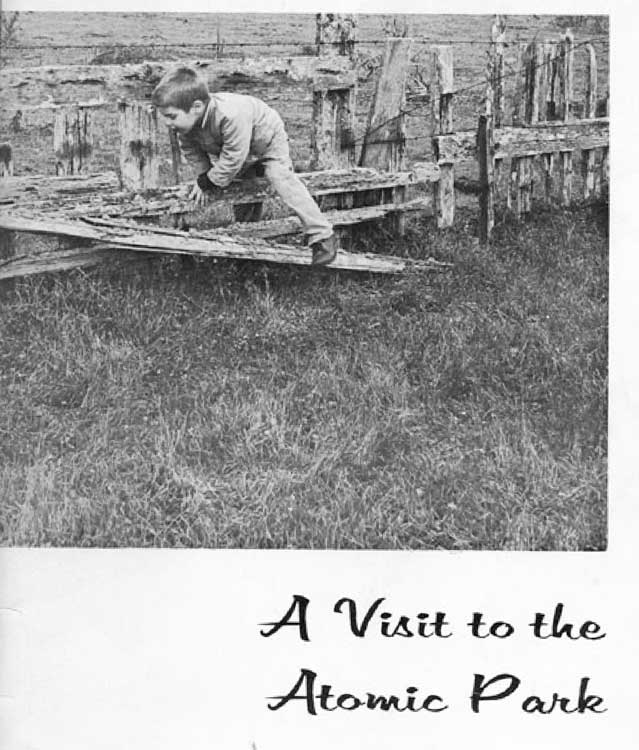 Young boy climbing a wooden fence.  Text is A Visit to the Atomic Park.