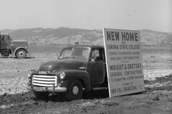 Old truck with a sign new home of Sonoma State College