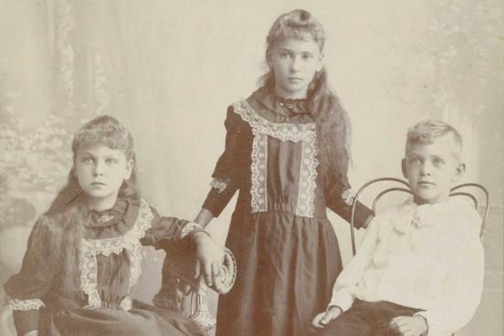 3 children posing for a photograph