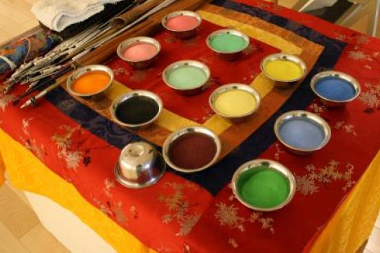 12 pot of different colored sand on a table.