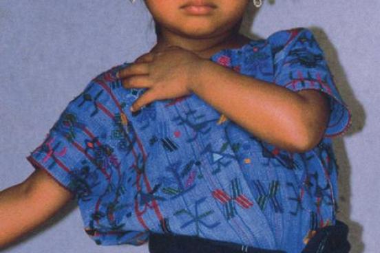 A young girl with a blue shirt and earnings.