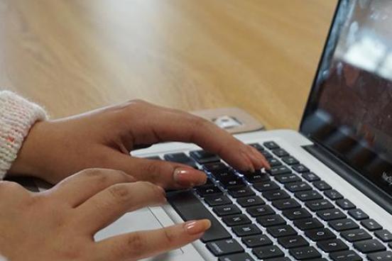 Hands typing on a keyboard.