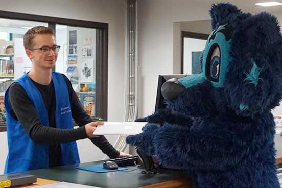 Person giving a book to Lobo Seawolf
