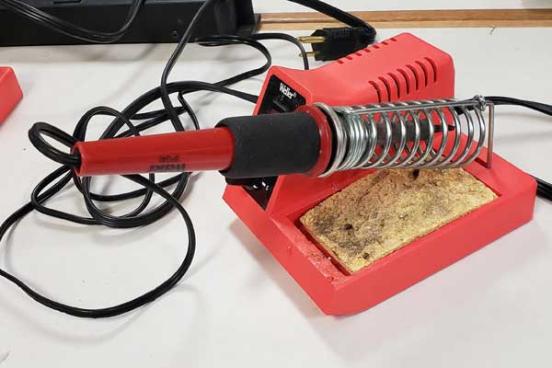 Tool with a red base, and electric cord.