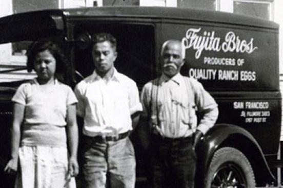 3 people stand in front of a truck.  The truck has "Quality Ranch Eggs" on the side.