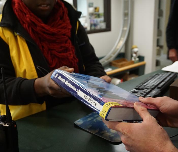 A book being checked out by a student