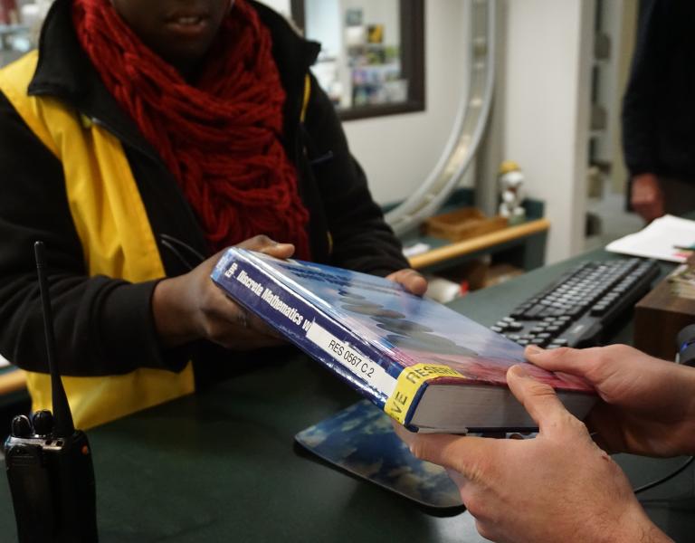 A book being checked out by a student
