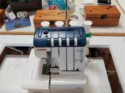 White sewing machine with blue top and 4 white levers.