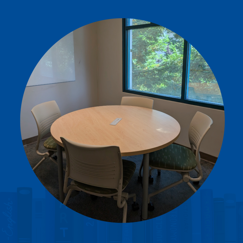 An table in a small room.  There are 4 empty chairs.