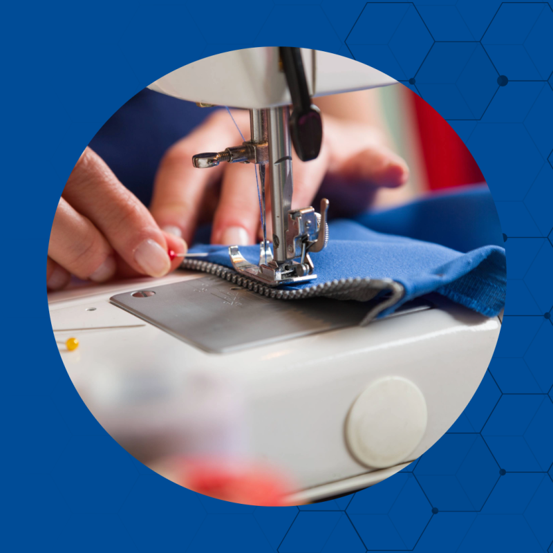 Close up of two hands moving a zipper in a sewing machine