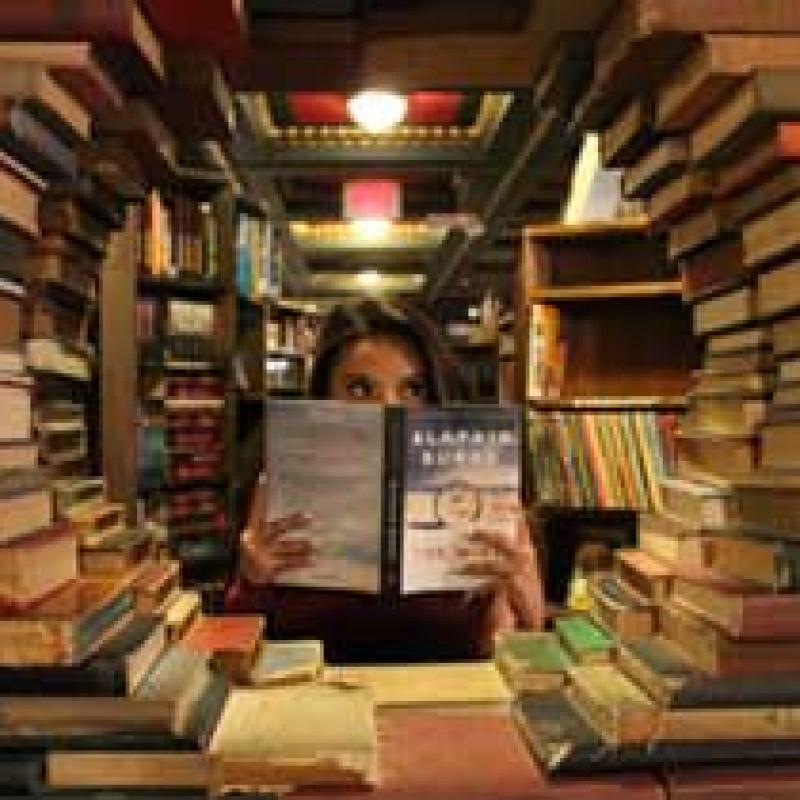 a woman is reading behind a circle of books.