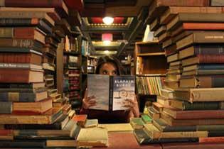 a woman is reading behind a circle of books.
