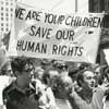 A protest with a large sign.  We are your children, Save our human rights.