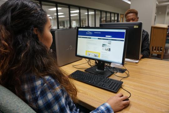 Student using one of the library computer workstations