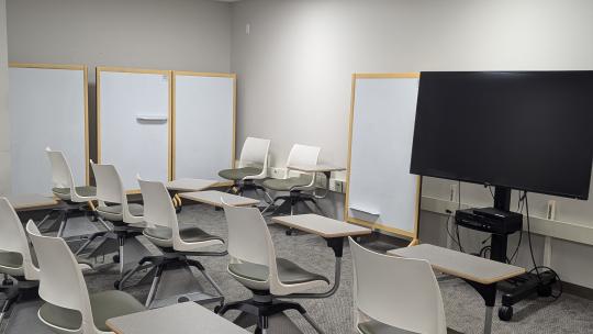 Large TV,  several chairs and whiteboards.