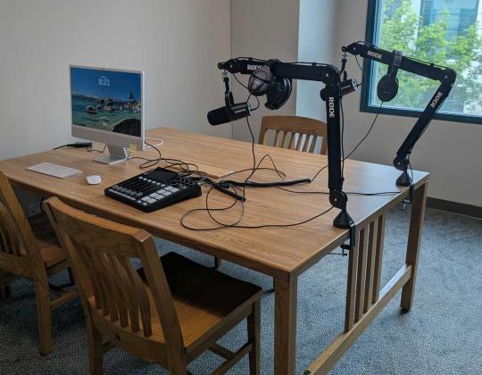 Desktop computer and 2 microphones are on a table.