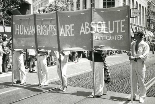 men carrying a banner that says Humans Righst are Absolute, Jimmy Carter