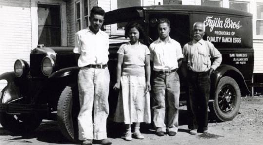 Four people standing in front of a truck.