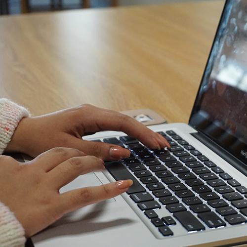 Hands typing on a keyboard.