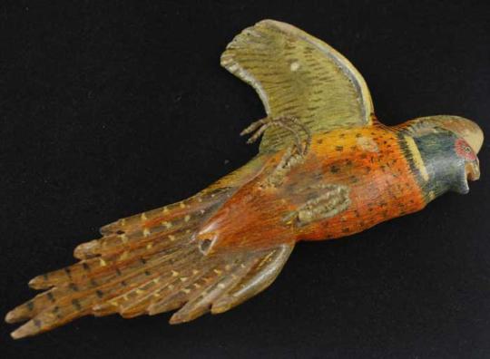 Carved bird, orange chest with yellow and brown wings.