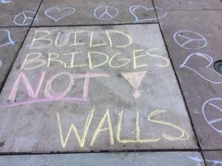 Chalk text of "Build Bridges Not Walls"