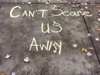 Chalk text of "Can't scare us away"