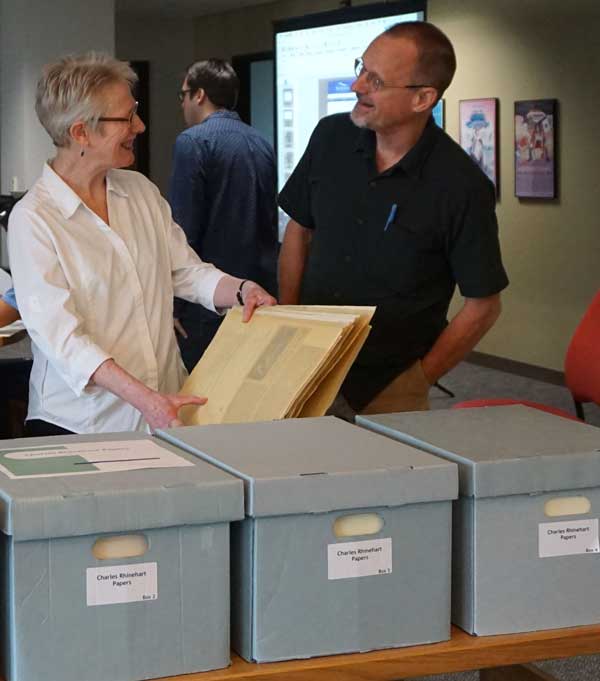 Woman and a man looking at archival documents.